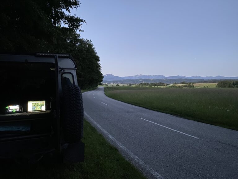 Einsatzfahrzeug bei der Rehkitzrettung neben einer Straße in Bayern. Im Kofferraum ist die Fernsteuerung einer Wärmebilddrohne sowie ein Laptop mit der POICloud zu sehen.